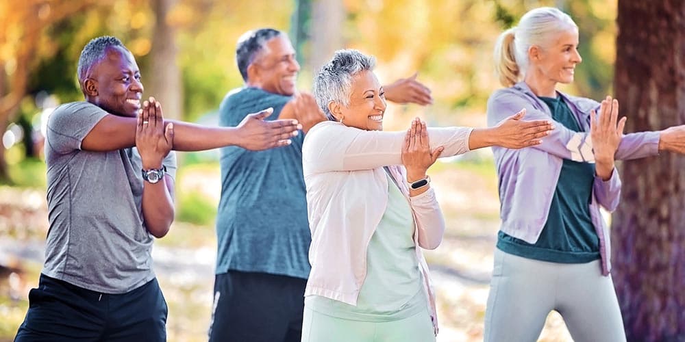 A diverse group of adults 50+ enjoying outdoor wellness movement together