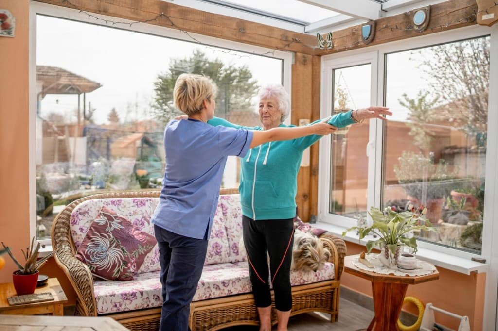 Physical therapist guiding an older adult with balance and movement